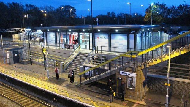 A platform at Marks Tey train station, with the station forecourt in the background