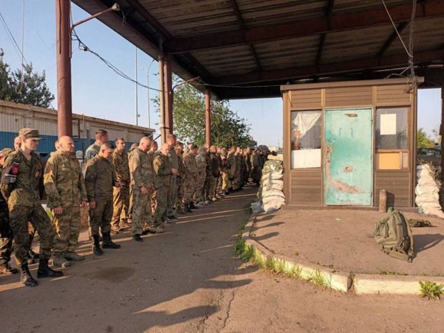 This photo released by Wagner Group says it shows Russian border guards at a checkpoint laying down their weapons