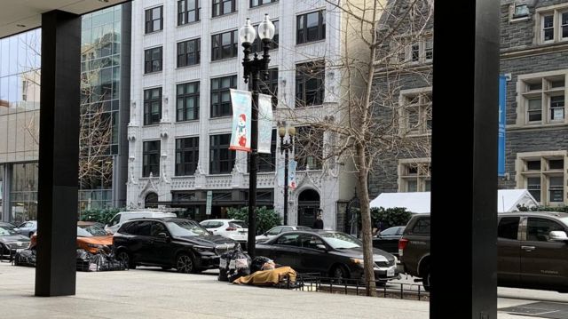Morador de rua dorme na calçada em frente à biblioteca central de Washington