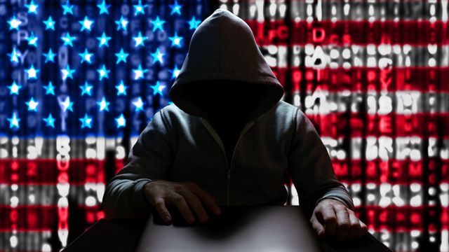 Un hacker con la bandera de EE.UU. de fondo