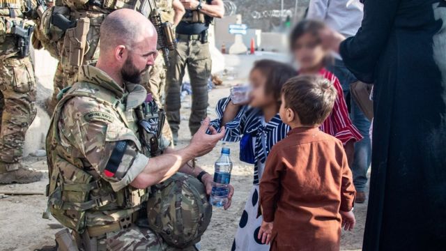 A soldier helps children.