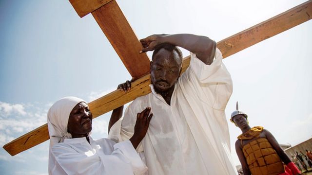 Aworan arakunrin kan ati Obinrin ni South Sudan ti wọn ṣe afihan bi Jesu ṣe gbe agbelebu