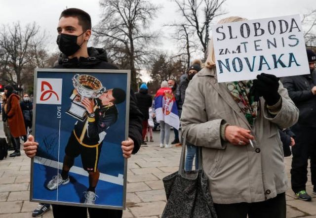 متظاهرون يرفعون صور جوكوفيتش أمام مبنى البرلمان الصربي في بليغراد تعبيراً عن دعمهم له.