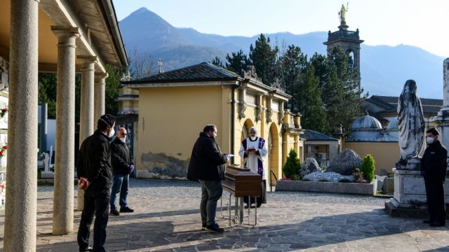 A priest celebrates funeral service without relatives inside the cemetery of Zogno, near Bergamo, northern Italy, on March 21, 2020
