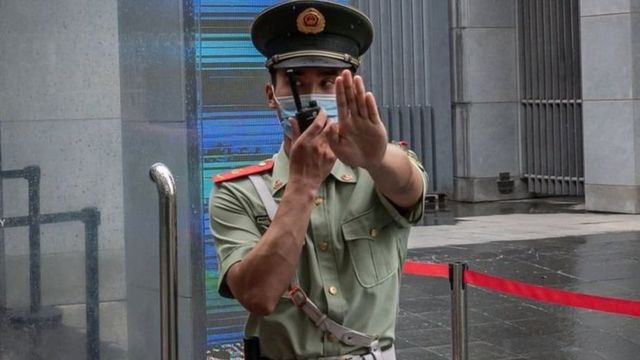 বেইজিং-এ অস্ট্রেলীয় দূতাবাসের সামনে একজন চীনা অফিসার।