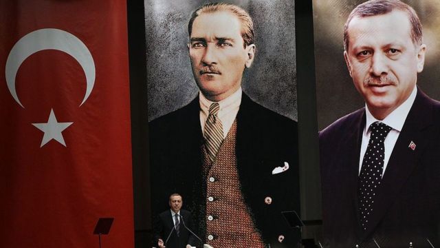 Erdogan habla frente a posters con su imagen y la de Ataturk.
