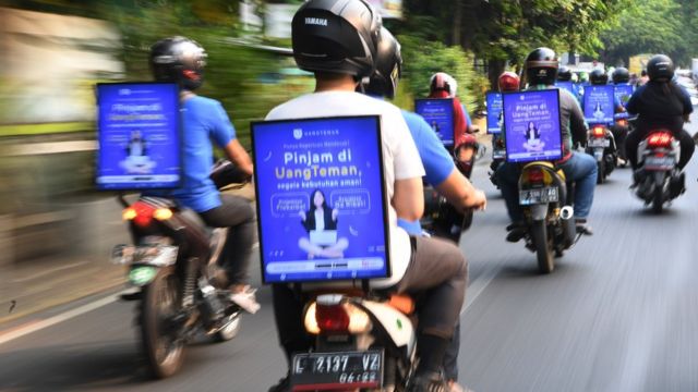 Pengendara ojek daring menggelar aksi konvoi sebagai sosialisasi layanan aplikasi UangTeman di Surabaya, Jawa Timur, Kamis (18/10).