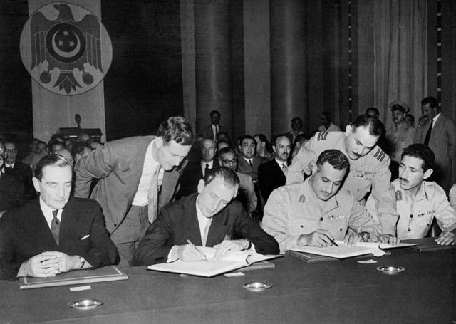 عبد الناصر (على اليمين ) وستيفنسن يوقعان في 21 أكتوبر/تشرين الأول عام 1954 اتفاقية جلاء القوات البريطانية من مصر