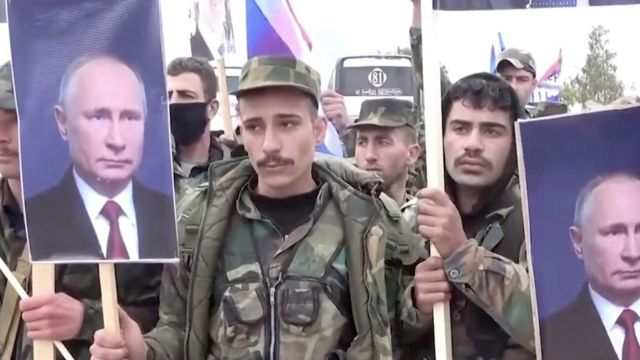 عناصر من الجيش السوري يحملون صورة الرئيس الروسي فلاديمير بوتين