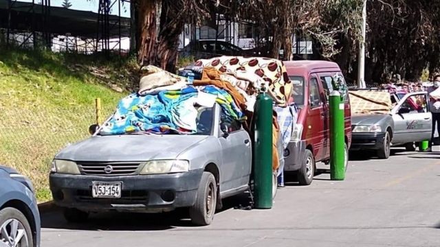 People line up in the street with their own oxygen balloons in Arequipa