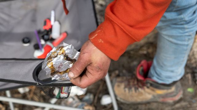 Un hombre sujeta papel de aluminio con el que quema fentanilo