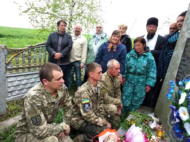 Dudarenko and his congregation hold a service at a monument to villagers killed by Nazis in 1941