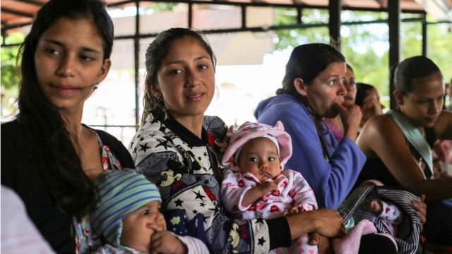 Mulheres com bebês na fila do posto de saúde