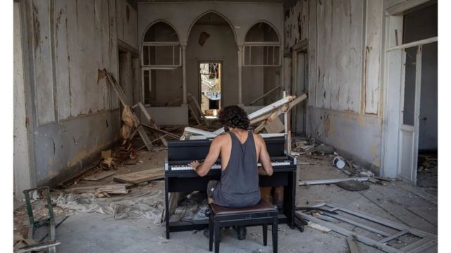 رايموند إيسايان يعزف البيانو في مبنى مدمر