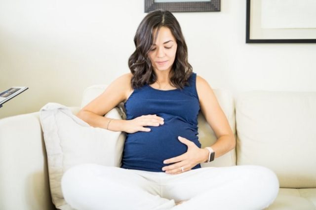 Pregnant woman lovingly holding her stomach