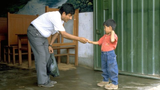 El Dr. Roger Zapata dando la mano al niño Luis Fermín Tenorio Cortez en 1991