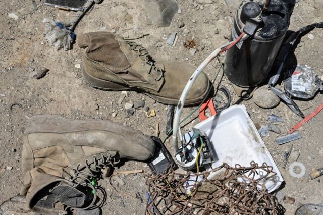 A pair of military boots lie on the floor next to other abandoned equipment in a scrap yard near Bagram airbase.
