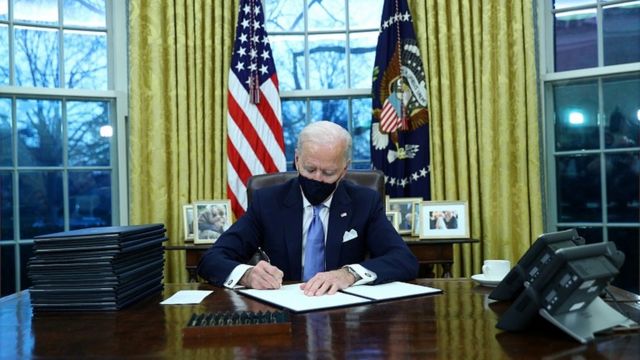 US President Joe Biden signs documents after being sworn-in