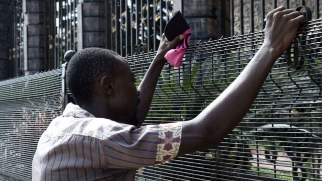 Un habitant pleure alors que des membres de l'église se rassemblent à l'entrée principale du siège de l'Église synagogue de toutes les nations (SCOA) pour pleurer le décès du pasteur nigérian TB Joshua, dans le quartier d'Ikotun à Lagos, le 6 juin 2021.