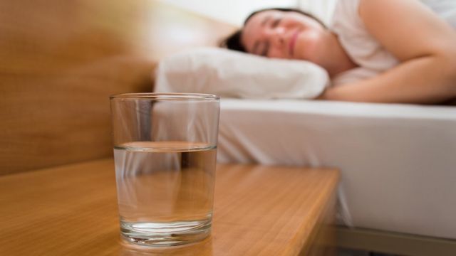 Persona durmiendo con vaso de agua