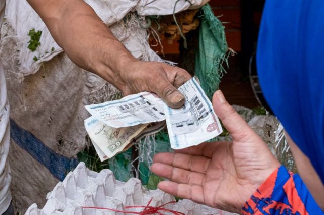 Cliente entrega notas de libras egípcias a vendedor 