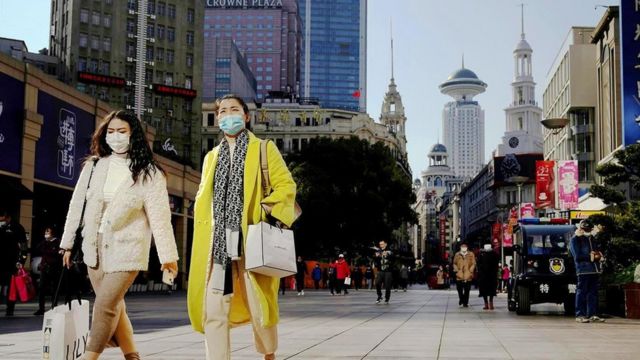 上海民众戴着防护口罩走在街上。