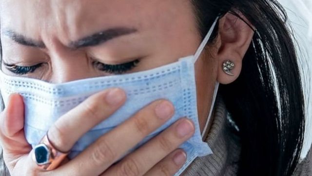 Mulher de máscara doente