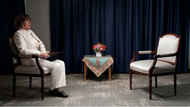 A jornalista da CNN Christiane Amanpour sentada em frente a uma cadeira vazia onde o presidente iraniano Ebrahim Raisi teria se sentado.