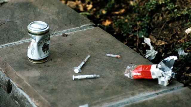 Seringas de heroína, lata de cerveja vazia e maço de cigarros em Taunusanlage, Frankfurt