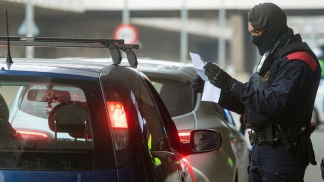 Un policía revisa documentos en un control en Cataluña.
