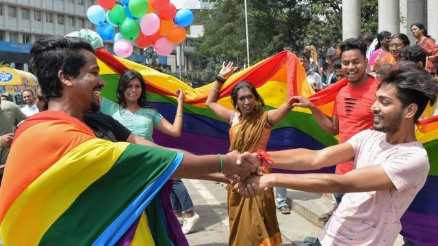 Indian LGBT activists and supporters celebrate the court ruling, dancing and holding up rainbow flags and balloons