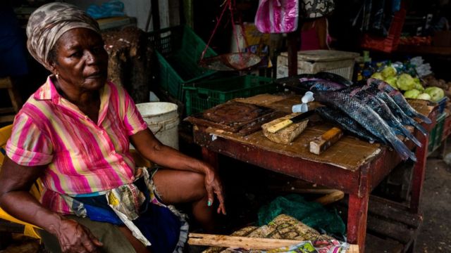 Mujer vende pescado en Colombia