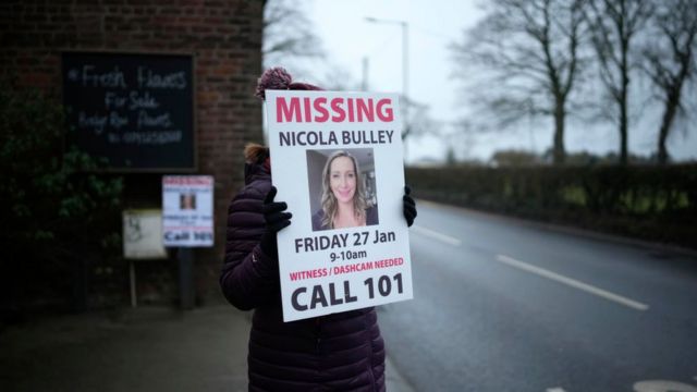 一位女士举起呼吁公众就失踪女子尼古拉·布勒下落提供情报的海报