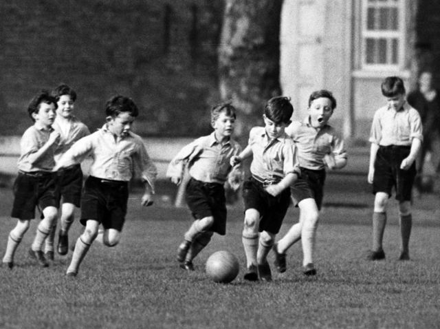 King Charles III (with ball at feet) playing football, 1957.