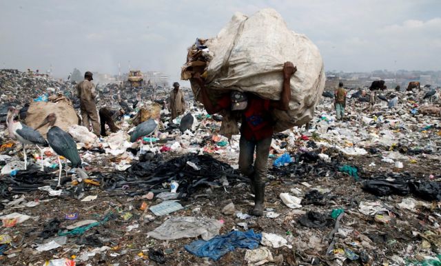 A scavenger carries recyclable plastic materials packed in a sack at the Dandora dumping site on the outskirts of Nairobi, Kenya August 25, 2017. Picture taken August 25, 2017.
