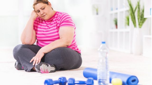 Una mujer sentada sin ganas de hacer ejercicio