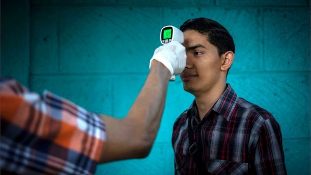 Funcionario toma la temperatura de un hombre en Nicaragua