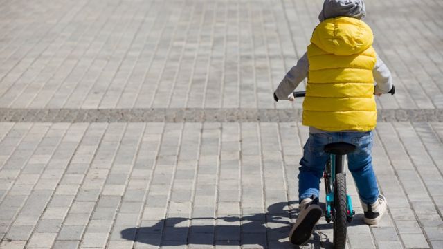 Niño de espaldas en bicicleta.