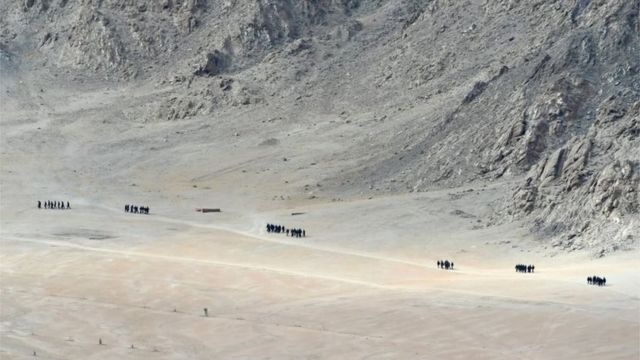 Indian soldiers walk at the foothills of a mountain range near Leh, the joint capital of the union territory of Ladakh, on June 25, 2020.