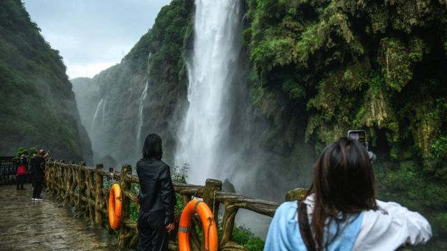 Turistas olhando para uma cachoeira