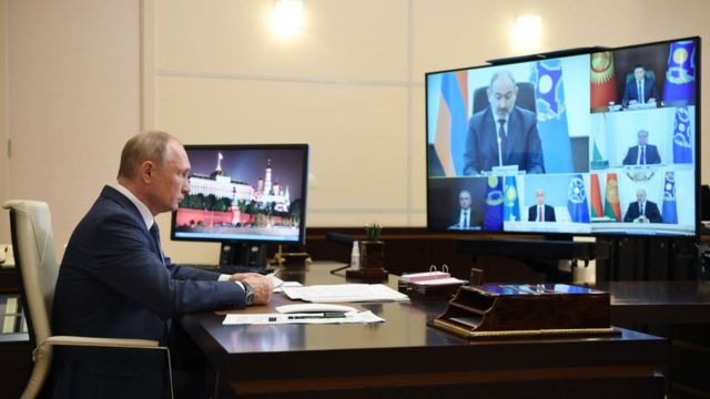 Putin en un escritorio con una pantalla enfrente que muestra a los demás presidentes de la Organización del Tratado de la Seguridad Colectiva.
