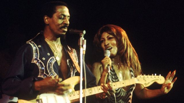 Tina Turner y su exesposo Ike Turner a la izquierda tocando la guitarra.