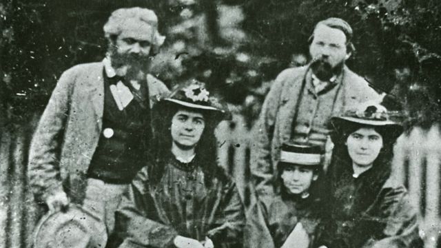 Eleanor, no meio, com suas irmãs Jenny (à esquerda) e Laura. Eles estão acompanhados por seu pai, Karl Marx, e seu amigo, Federico Engels