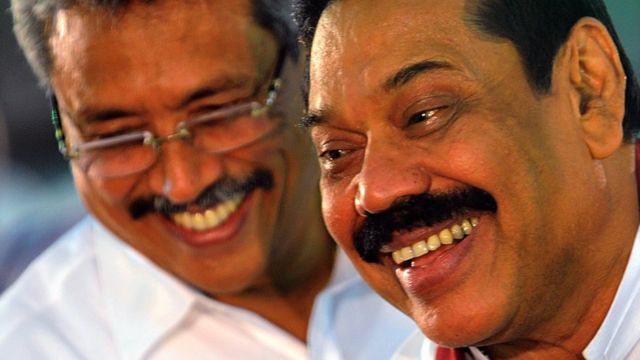 Sri Lankan President Mahinda Rajapakse (R) and Sri Lankan Defence Ministry Secretary Gotabaya Rajapaksa (L) walk past Buddhist monks during the War Heroes religion ceremony in Colombo on May 9, 2013.