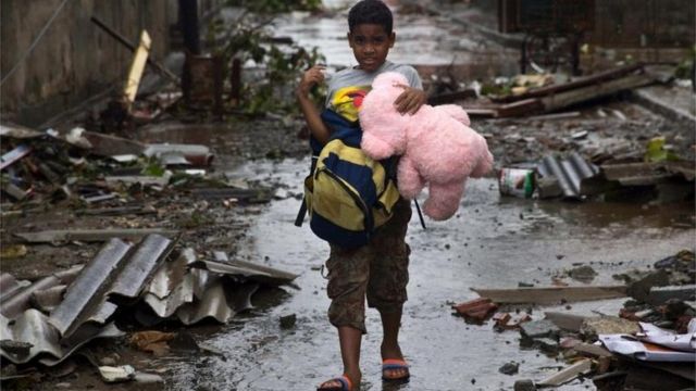 Un niño camina por las calles devastadas en Baracoa con un oso de peluche en la mano