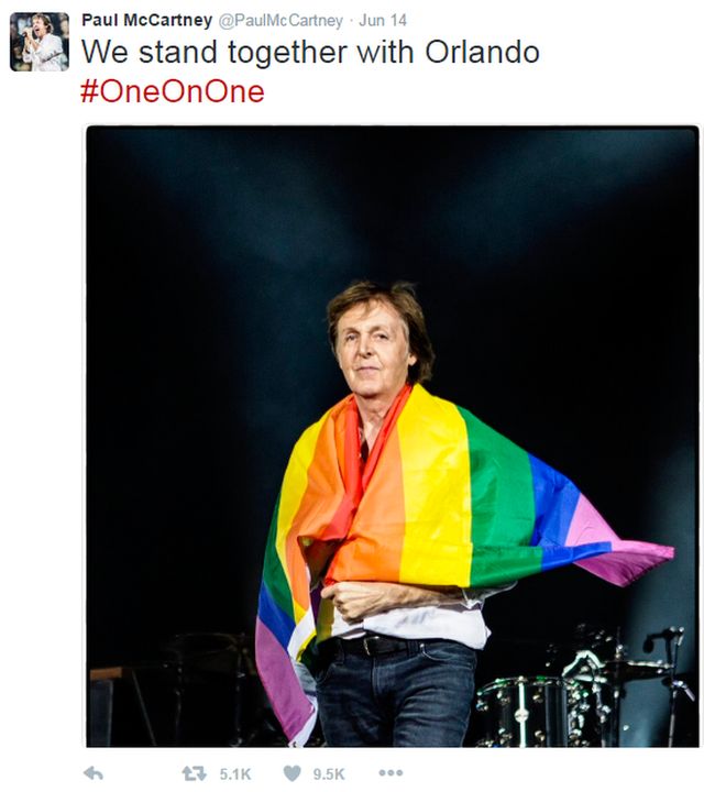 Paul McCartney envuelto en una bandera de arcoíris.