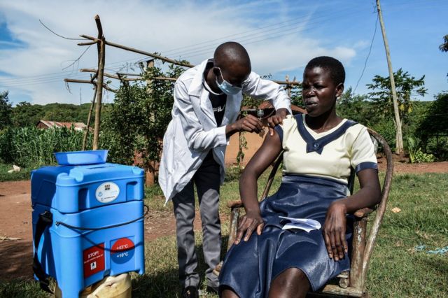 A health worker vaccinates a woman in Siaya, Kenya