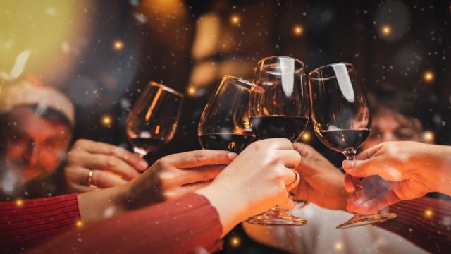 A group of people toast with glasses of wine.