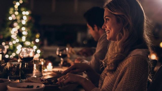Mujer sonriendo durante la cena de Navidad.