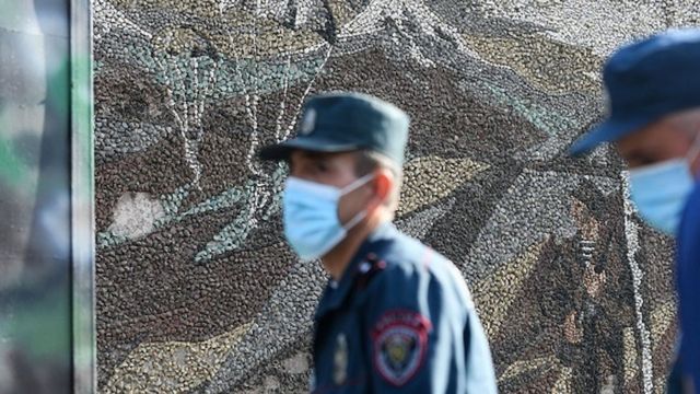 Üzlərində tibbi maska olan polis əməkdaşları